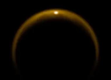 NASA のカッシーニ宇宙船が撮影した写真。 土星の月タイタンの表面にある液体メタンの湖からの光の鏡面反射を示しています。